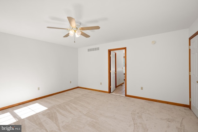 unfurnished room featuring carpet, visible vents, a ceiling fan, and baseboards