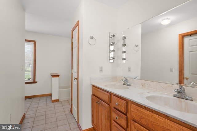 bathroom featuring tile patterned floors, baseboards, a sink, and double vanity