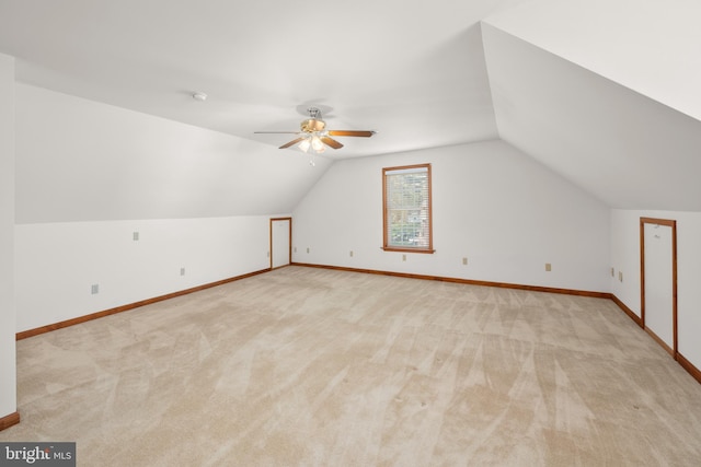 additional living space featuring lofted ceiling, light carpet, and baseboards