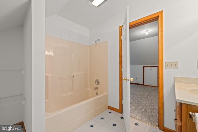 bathroom featuring tile patterned flooring, baseboards, vanity, and washtub / shower combination