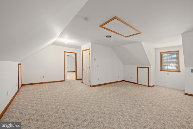 additional living space with vaulted ceiling, carpet flooring, visible vents, and baseboards
