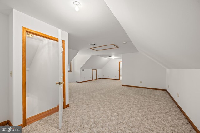 additional living space featuring baseboards, lofted ceiling, and carpet
