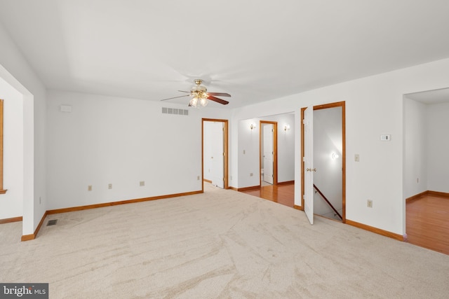 interior space featuring a ceiling fan, visible vents, and carpet