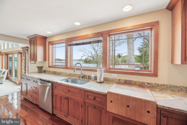 kitchen featuring a sink, dark wood-style flooring, light stone countertops, brown cabinetry, and dishwasher
