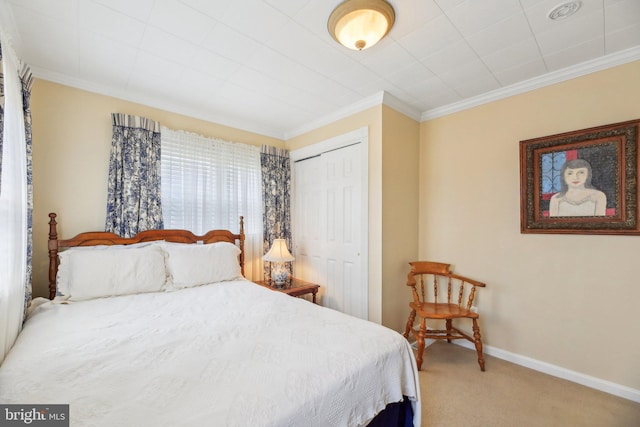 carpeted bedroom featuring baseboards, ornamental molding, and a closet