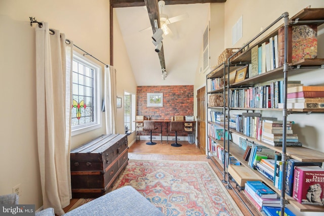 sitting room with wood finished floors, beam ceiling, a ceiling fan, and high vaulted ceiling