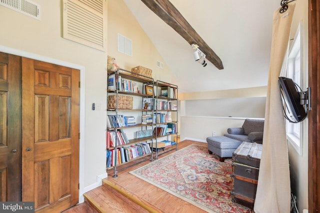 sitting room featuring lofted ceiling, visible vents, baseboards, and wood finished floors