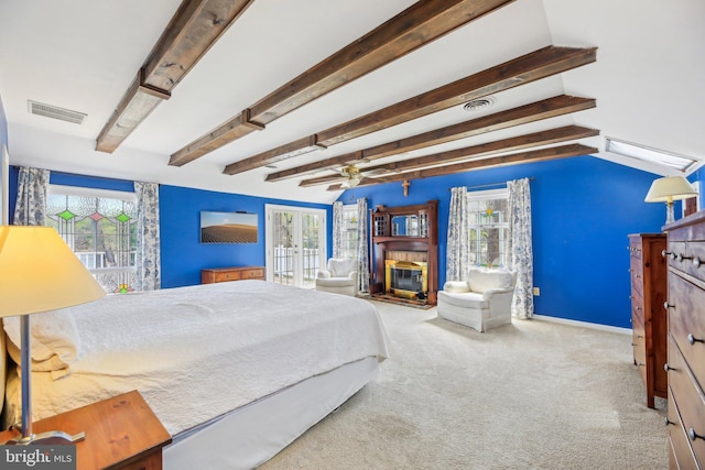 carpeted bedroom with baseboards, beamed ceiling, a glass covered fireplace, and visible vents