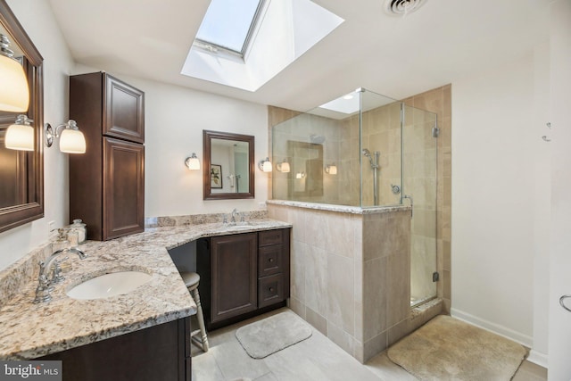 bathroom with a stall shower, visible vents, a skylight, tile patterned flooring, and vanity