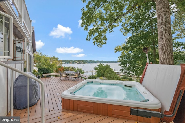 wooden deck featuring a water view and hot tub deck surround