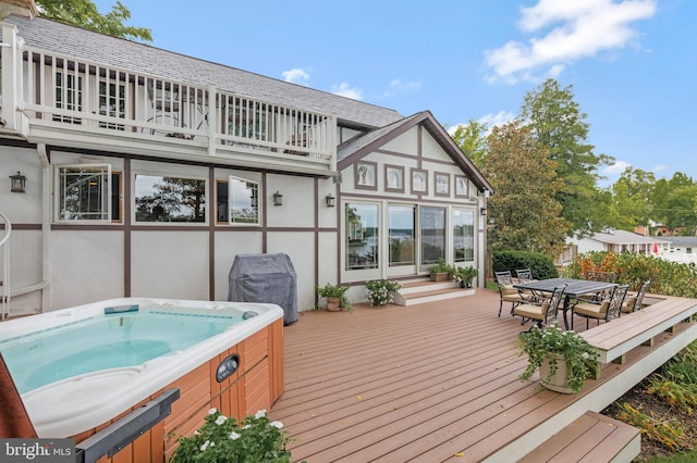 wooden deck with grilling area, a hot tub, and outdoor dining area