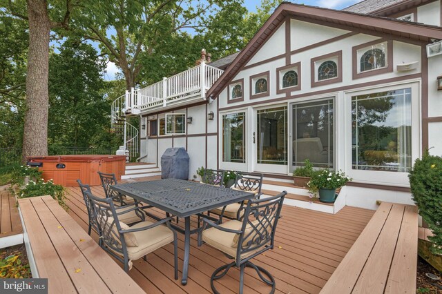 deck with stairs, area for grilling, a hot tub, and outdoor dining area