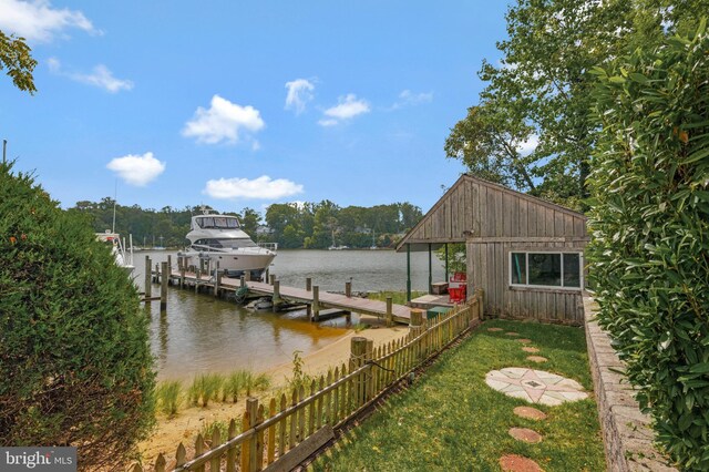 view of dock with boat lift, fence, and a water view