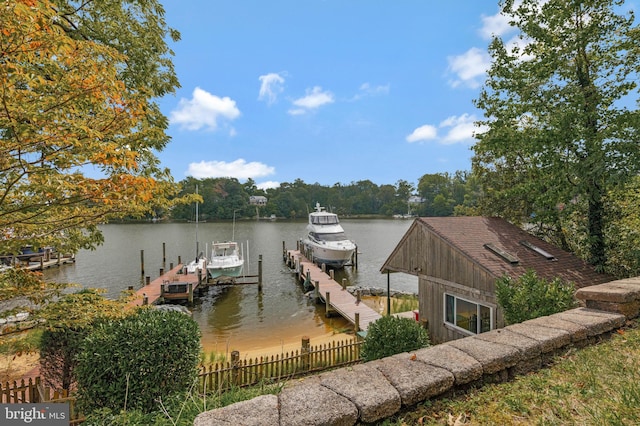 dock area with fence, boat lift, and a water view