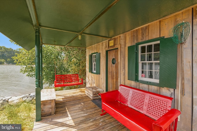 wooden deck featuring a porch and a water view