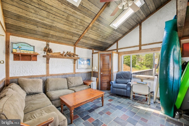 living room with wooden ceiling, stone finish floor, lofted ceiling with skylight, and ceiling fan