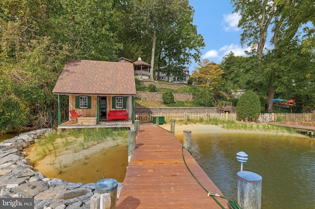 view of dock with fence and a water view