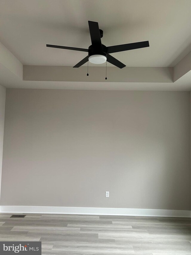 unfurnished room with light wood-style flooring, baseboards, a ceiling fan, and visible vents