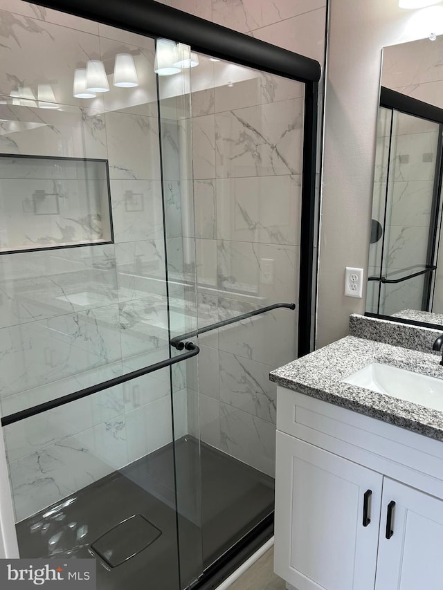 bathroom featuring a shower stall and vanity