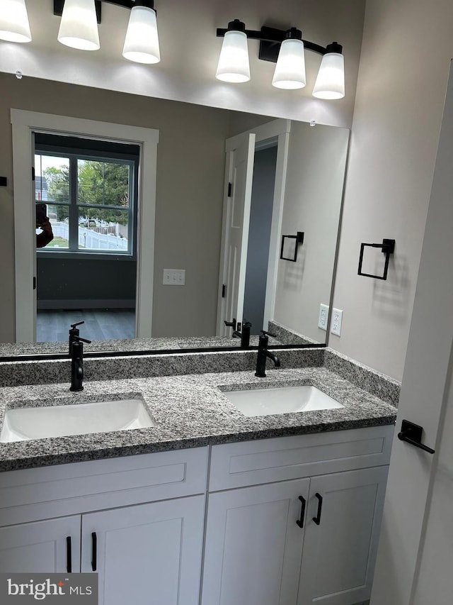 bathroom featuring a sink and double vanity