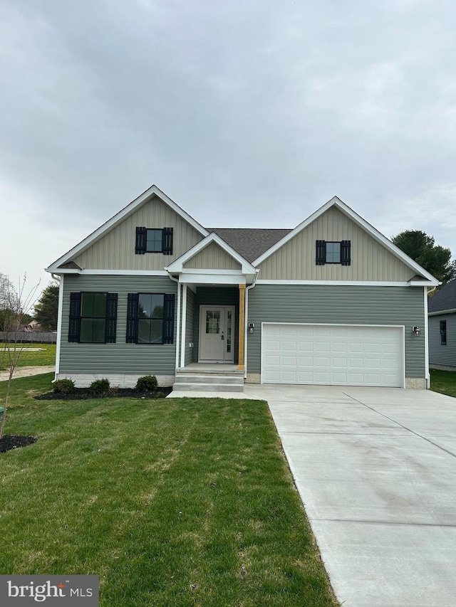 view of front of house with board and batten siding, a front lawn, an attached garage, and concrete driveway