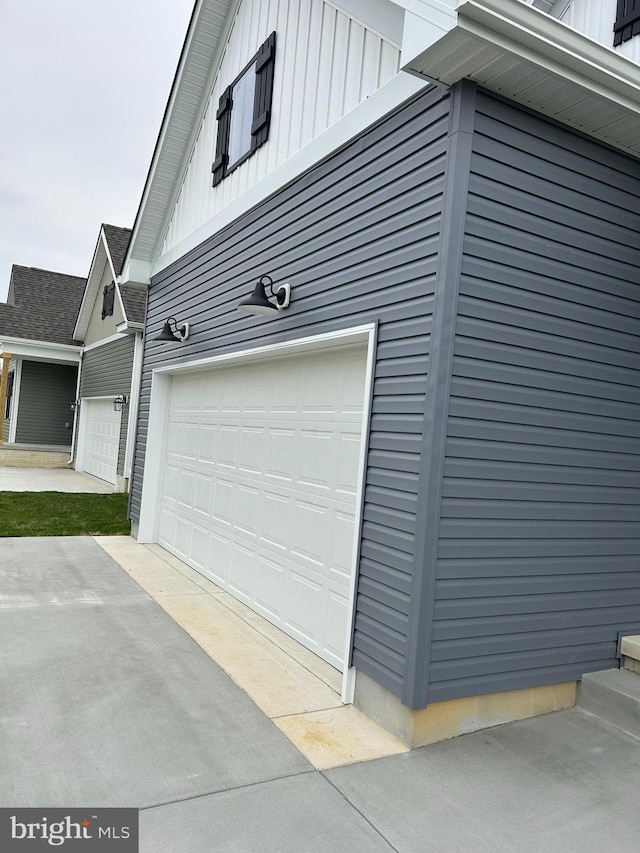 view of side of home with a garage, driveway, and board and batten siding
