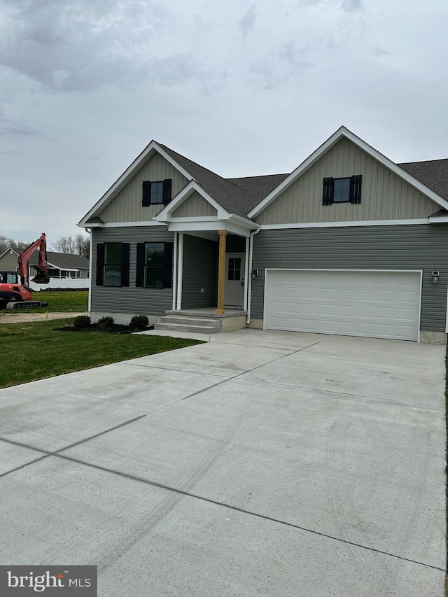 view of front of house featuring an attached garage, board and batten siding, driveway, and a front lawn