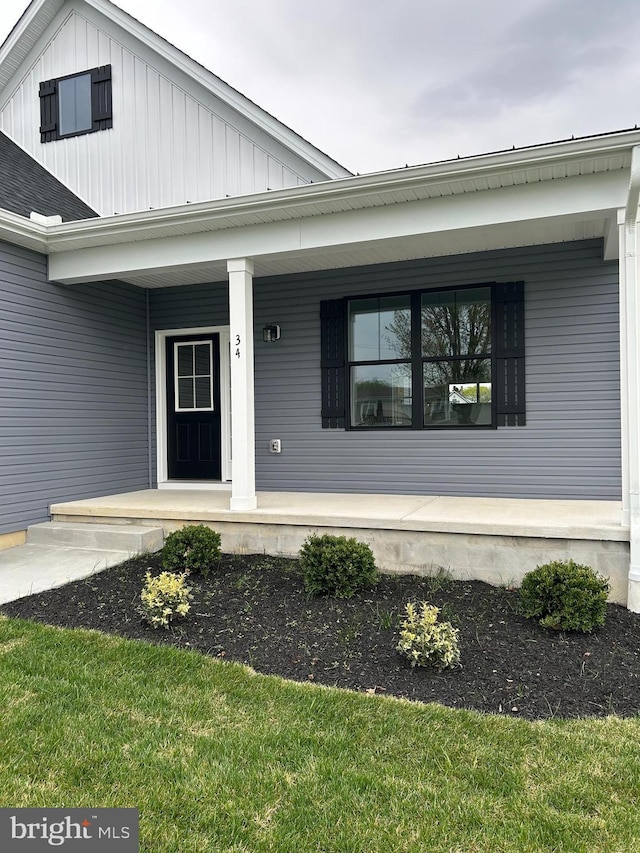 property entrance with board and batten siding and a porch