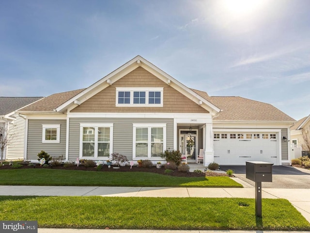 34851 Surfsong Lndg, Millville, DE 19967 - craftsman-style home with an attached garage, driveway, a shingled roof, and a front lawn