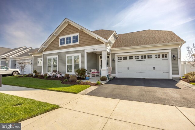 34851 Surfsong Lndg, Millville, DE 19967 - craftsman house featuring a shingled roof, driveway, covered porch, a front yard, and a garage