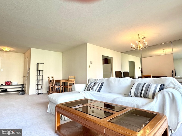living area with an inviting chandelier, carpet floors, and a textured ceiling