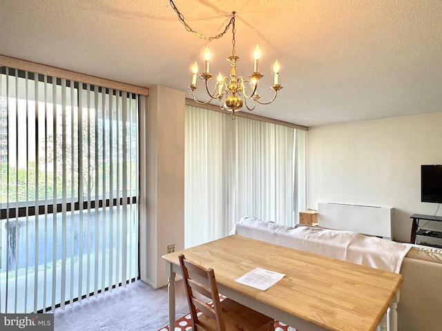 dining room with carpet flooring, a textured ceiling, and a chandelier