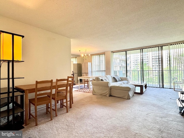 living room with an inviting chandelier, a textured ceiling, and carpet