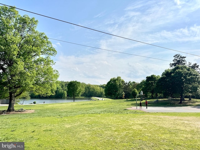 surrounding community with a lawn and a water view