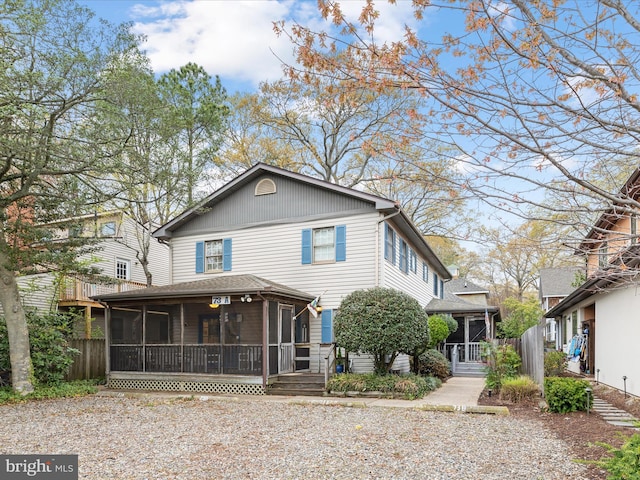 rear view of house with fence and a sunroom