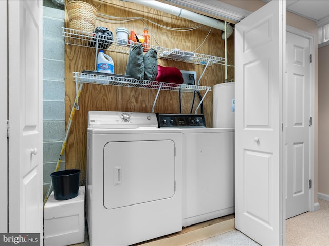 clothes washing area featuring gas water heater, separate washer and dryer, and laundry area