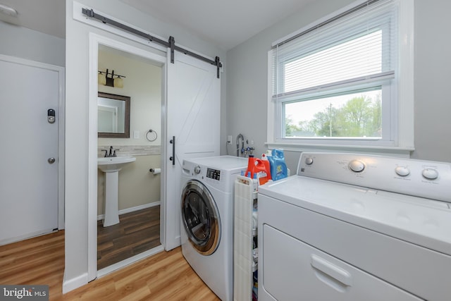 119 Field, Penns Grove, NJ 08069 - laundry room with a barn door, a sink, washer and clothes dryer, light wood-style floors, and laundry area