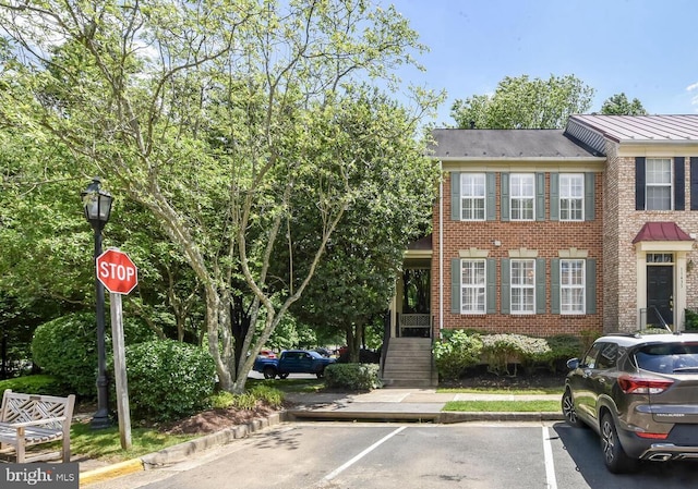11431 Heritage Commons Way, Reston, VA 20194 - view of front facade featuring uncovered parking, brick siding, metal roof, and a standing seam roof
