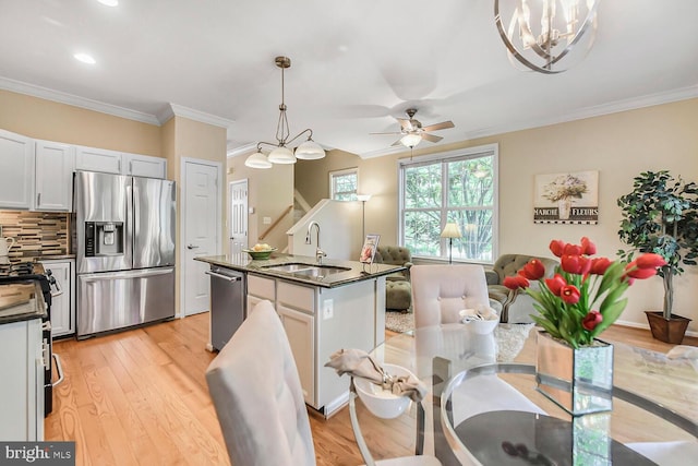 11431 Heritage Commons Way, Reston, VA 20194 - kitchen with stainless steel appliances, a sink, dark countertops, an island with sink, and ornamental molding