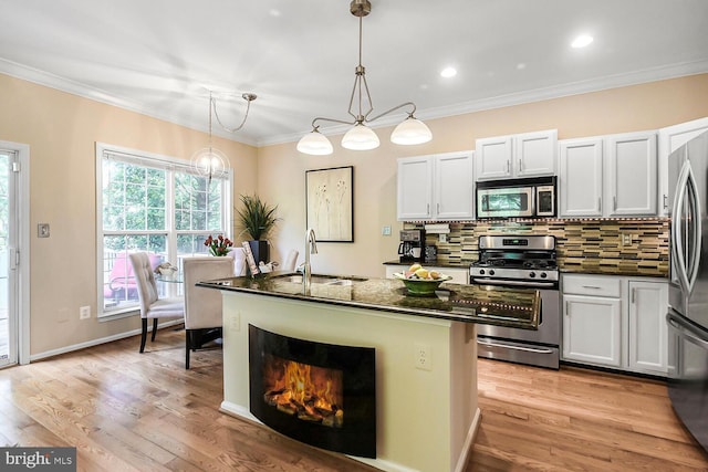 11431 Heritage Commons Way, Reston, VA 20194 - kitchen featuring appliances with stainless steel finishes, a sink, tasteful backsplash, a kitchen island with sink, and white cabinetry