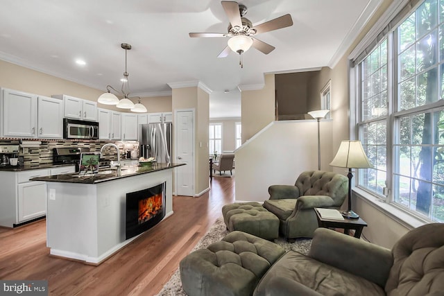 11431 Heritage Commons Way, Reston, VA 20194 - kitchen featuring appliances with stainless steel finishes, open floor plan, dark countertops, crown molding, and tasteful backsplash