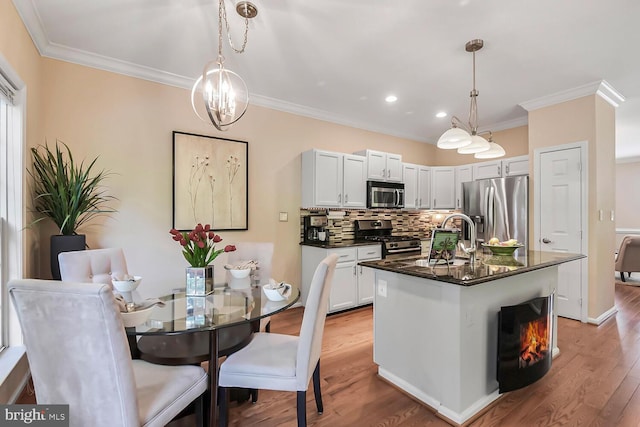 11431 Heritage Commons Way, Reston, VA 20194 - kitchen featuring stainless steel appliances, a sink, ornamental molding, tasteful backsplash, and light wood finished floors