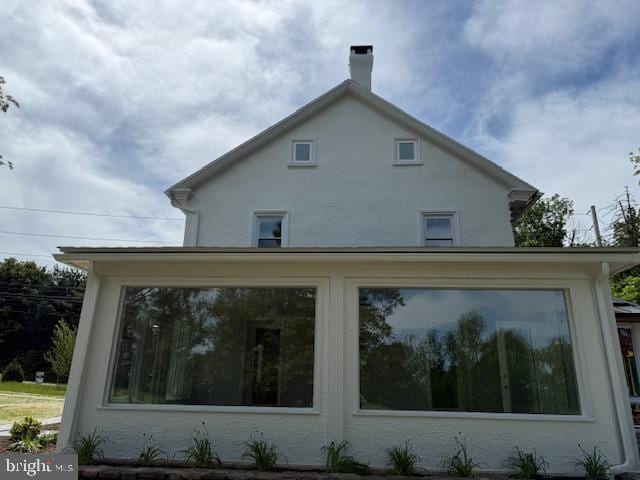 639 Old Airport Rd, Douglassville, PA 19518 - view of home's exterior with a sunroom, stucco siding, and a chimney