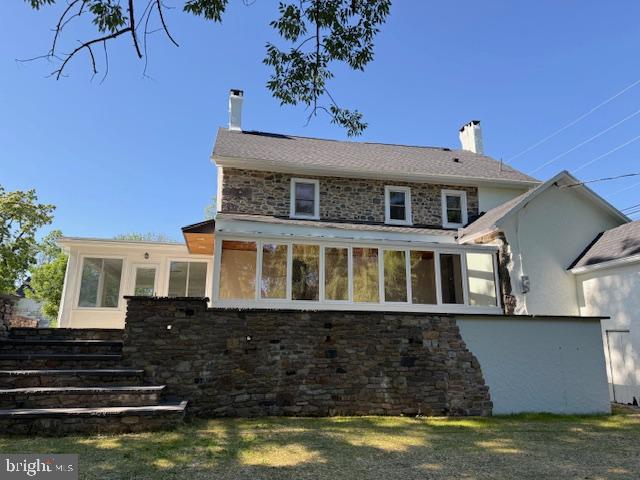 639 Old Airport Rd, Douglassville, PA 19518 - rear view of house with a chimney, stone siding, and a sunroom