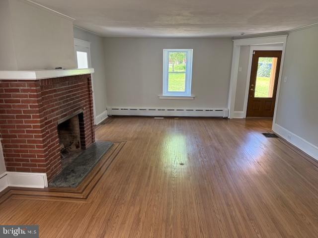 639 Old Airport Rd, Douglassville, PA 19518 - unfurnished living room featuring plenty of natural light, a brick fireplace, and wood finished floors