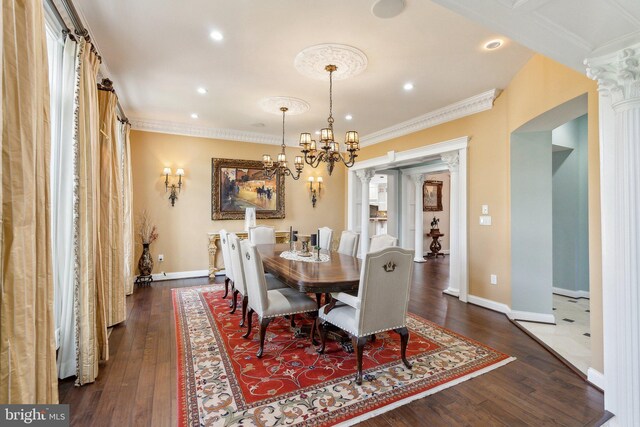 dining space featuring ornamental molding, decorative columns, dark wood finished floors, and a chandelier