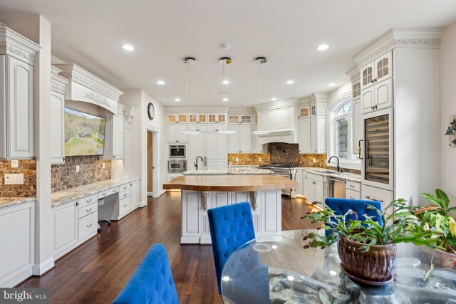 kitchen with beverage cooler, a sink, stainless steel appliances, and tasteful backsplash