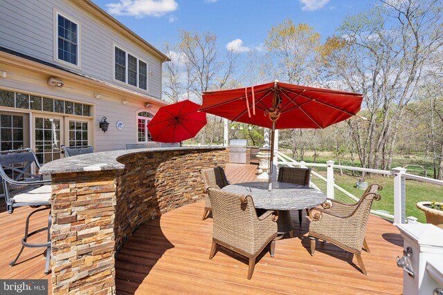 deck with outdoor dining area and outdoor wet bar