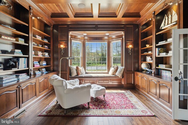living area with crown molding, wood walls, built in features, hardwood / wood-style floors, and wood ceiling