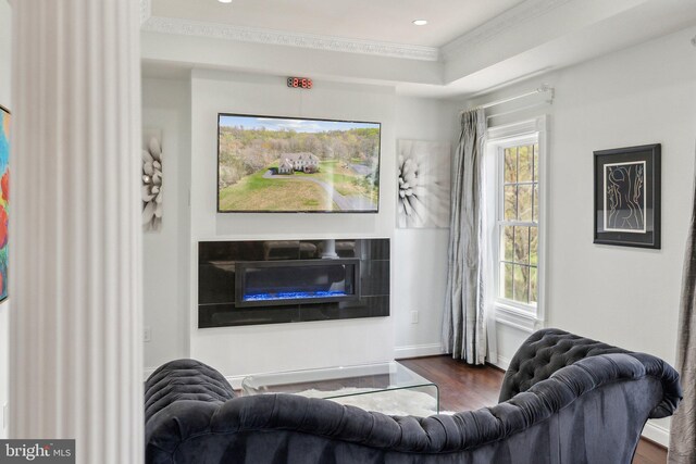 living area with crown molding, a glass covered fireplace, recessed lighting, and wood finished floors
